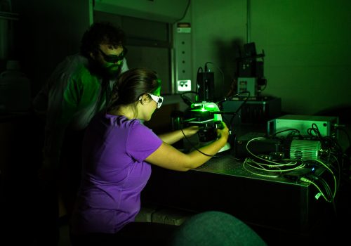 Physics professor using a laser with a student