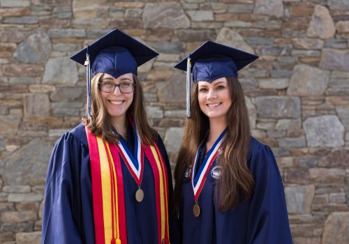 Former physics students Wren Gregory and Ashlyn Rickard in graduation attire.